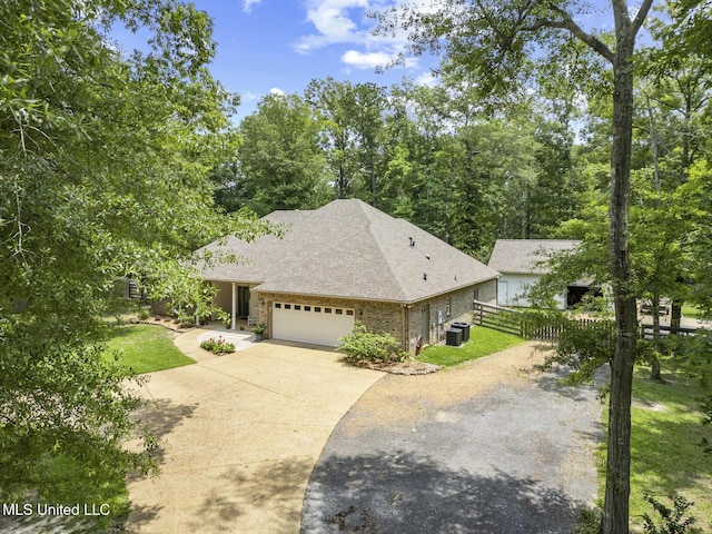 114 Sandstone Dr, Brandon, MS 39047 - view of front of house with driveway, central air condition unit, a garage, a shingled roof, and brick siding