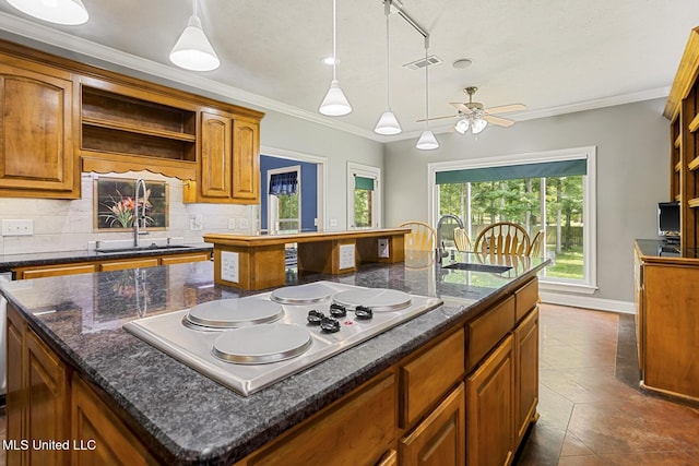114 Sandstone Dr, Brandon, MS 39047 - kitchen with stainless steel electric stovetop, a sink, an island with sink, open shelves, and crown molding