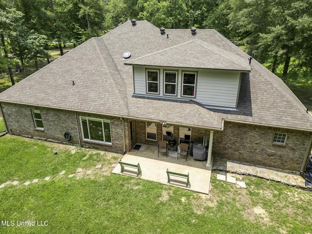 114 Sandstone Dr, Brandon, MS 39047 - back of house with a shingled roof, a patio, brick siding, and a yard