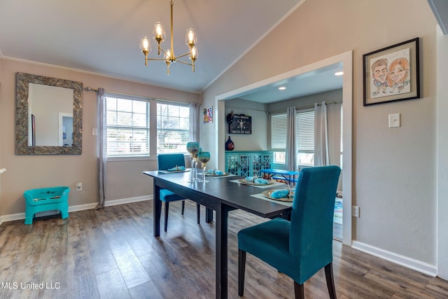 dining room with an inviting chandelier, lofted ceiling, ornamental molding, and hardwood / wood-style flooring