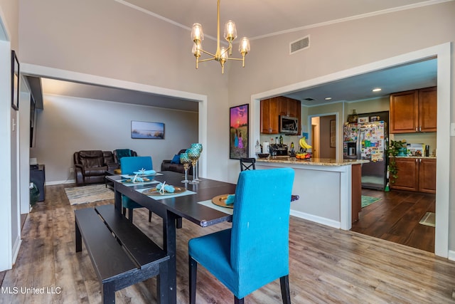 dining room with crown molding, a notable chandelier, and wood-type flooring