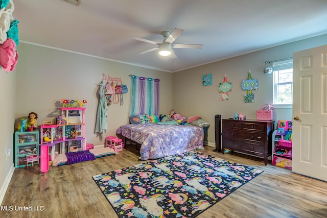 bedroom featuring ceiling fan, ornamental molding, and light hardwood / wood-style floors