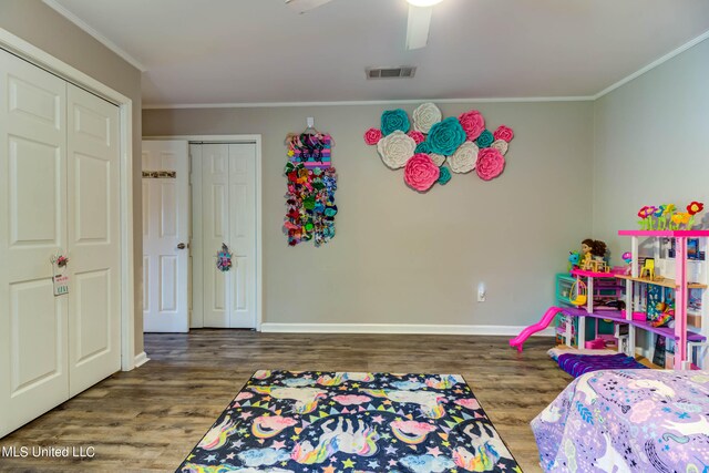 bedroom with a closet, ceiling fan, crown molding, and wood-type flooring