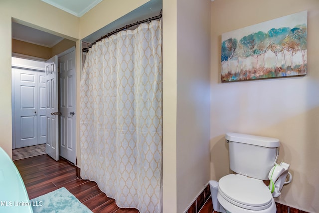 bathroom featuring toilet, crown molding, curtained shower, and hardwood / wood-style floors