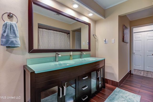 bathroom featuring vanity, crown molding, and hardwood / wood-style flooring