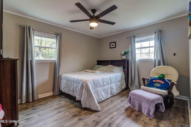 bedroom with ceiling fan, hardwood / wood-style flooring, ornamental molding, and multiple windows