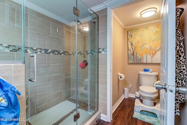 bathroom with a shower with door, ornamental molding, and toilet