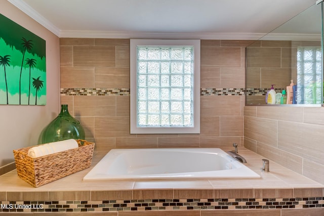 bathroom with ornamental molding and tiled bath