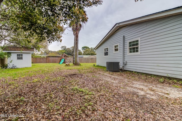 view of yard featuring central air condition unit, a storage unit, and a playground