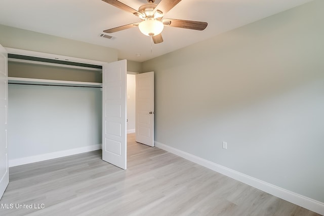 unfurnished bedroom with ceiling fan, light wood-type flooring, and a closet