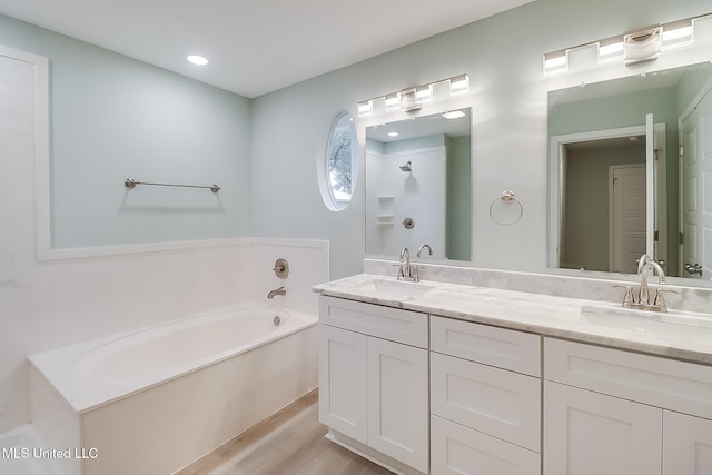 bathroom with hardwood / wood-style floors, vanity, and a tub to relax in