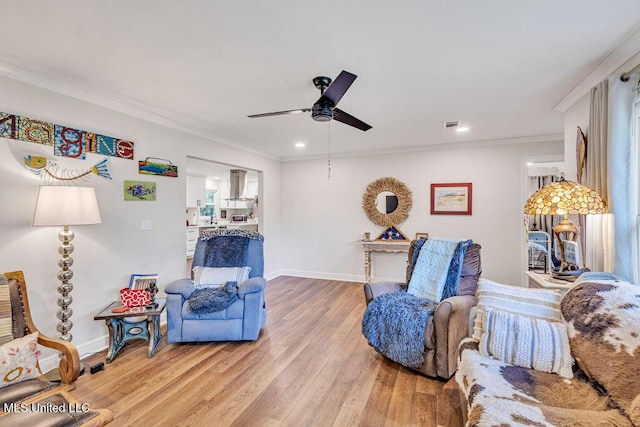 sitting room with hardwood / wood-style floors, ornamental molding, and ceiling fan