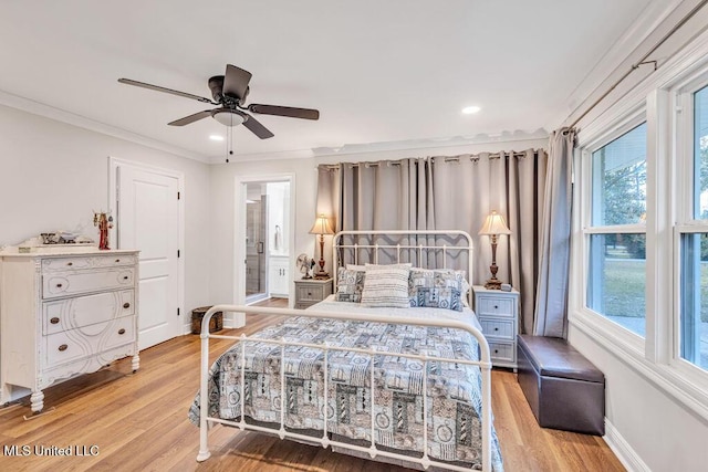 bedroom with ceiling fan, ensuite bathroom, multiple windows, and hardwood / wood-style flooring