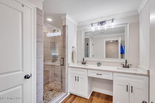 bathroom featuring an enclosed shower, vanity, ornamental molding, and hardwood / wood-style flooring
