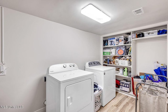 laundry room with independent washer and dryer and light hardwood / wood-style floors