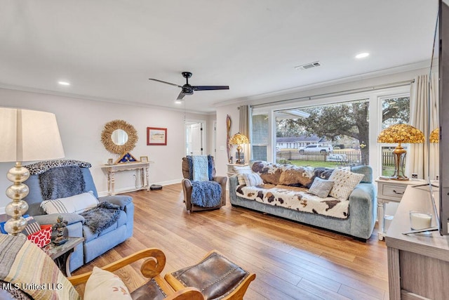 living room featuring crown molding, ceiling fan, light hardwood / wood-style floors, and plenty of natural light