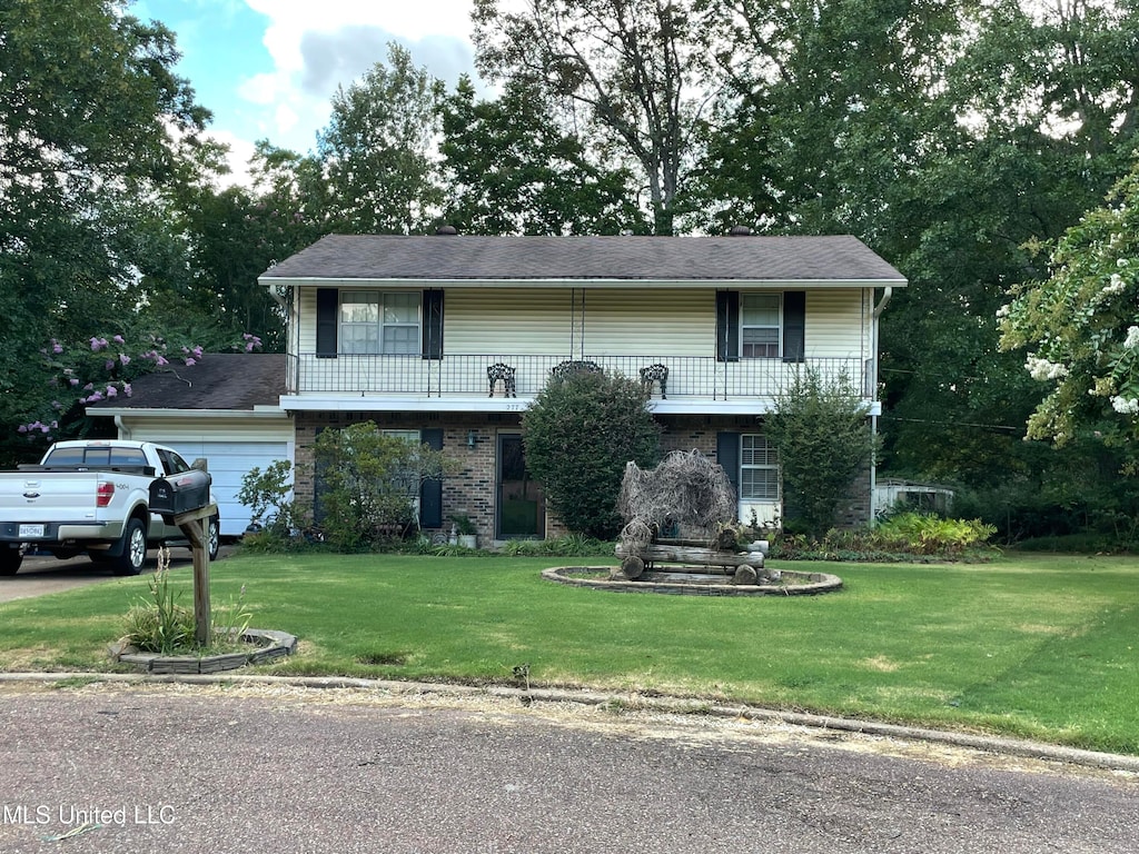 split foyer home featuring a front lawn and a garage