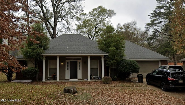 view of front of house featuring a shingled roof, a porch, and a garage