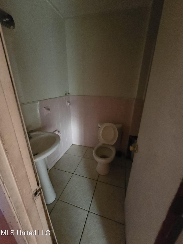 bathroom with toilet, tile patterned floors, and sink