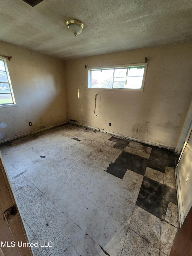 unfurnished room with a textured ceiling