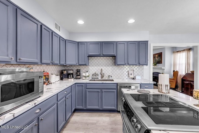 11020 Jordan Dr, Bay Saint Louis, MS 39520 - kitchen featuring a sink, stainless steel microwave, range, and backsplash