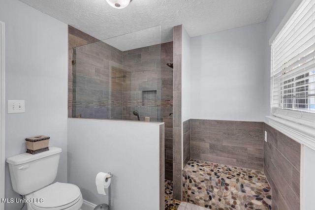 11020 Jordan Dr, Bay Saint Louis, MS 39520 - full bathroom featuring toilet, a walk in shower, and a textured ceiling