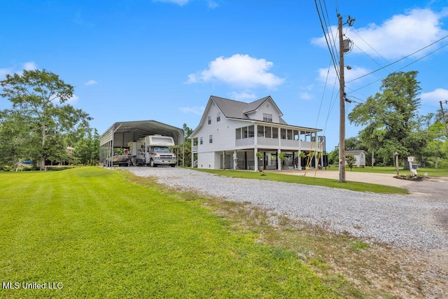 11020 Jordan Dr, Bay Saint Louis, MS 39520 - coastal inspired home featuring a front lawn, a carport, and driveway