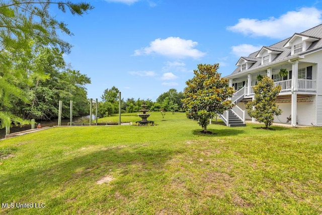 11020 Jordan Dr, Bay Saint Louis, MS 39520 - view of grassy yard with a porch, stairs, and a water view