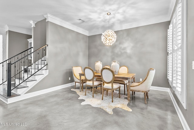 dining room with decorative columns, a chandelier, concrete floors, and ornamental molding