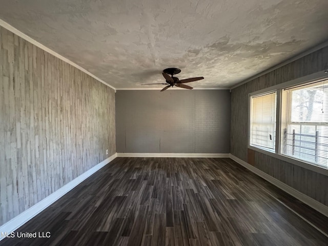 unfurnished room with dark hardwood / wood-style floors, ceiling fan, ornamental molding, and wood walls