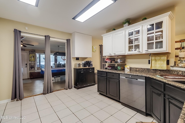 kitchen with ceiling fan, dishwasher, light tile patterned flooring, dark stone countertops, and white cabinets