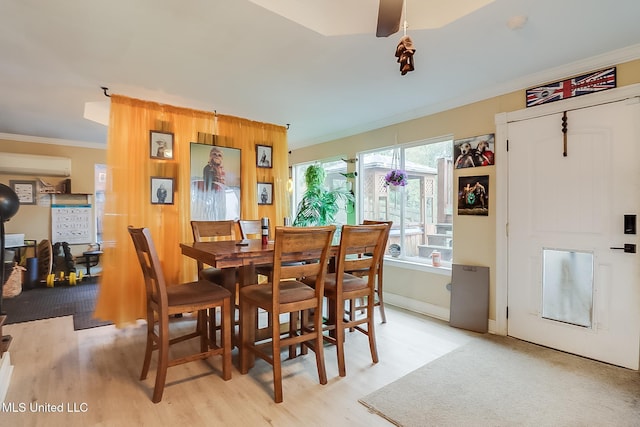 dining room featuring an AC wall unit, crown molding, and light hardwood / wood-style floors