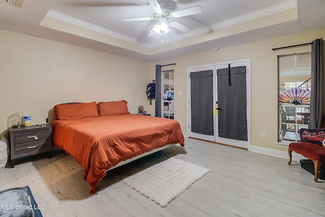 bedroom with access to exterior, a tray ceiling, ceiling fan, and light hardwood / wood-style floors