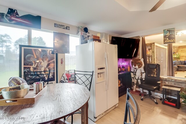 kitchen featuring light wood-type flooring, white fridge with ice dispenser, and ornamental molding