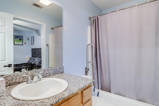 full bathroom featuring vanity, shower / bath combo, and toilet