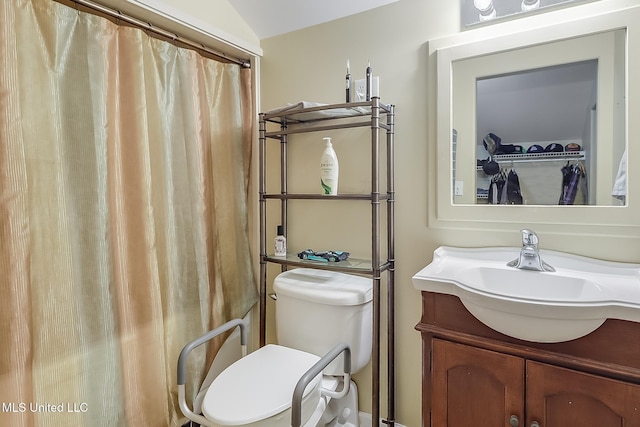 bathroom with a shower with shower curtain, vanity, toilet, and vaulted ceiling