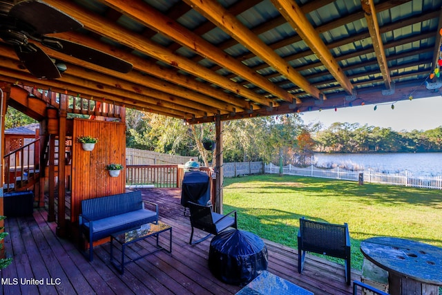 wooden terrace with grilling area, a yard, and a water view