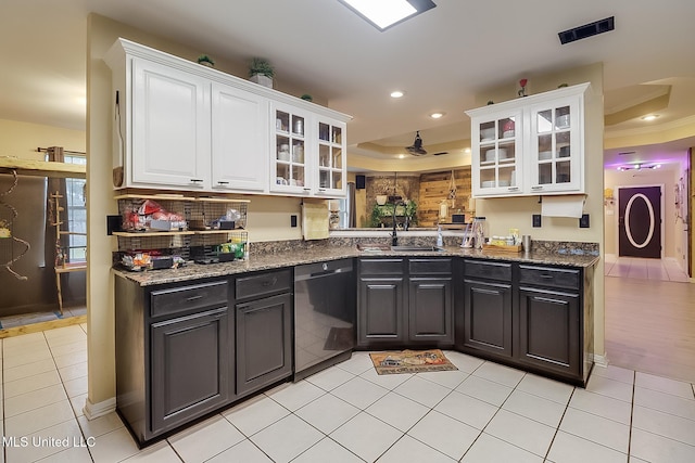 kitchen featuring dishwasher, sink, a raised ceiling, dark stone counters, and white cabinets