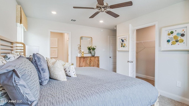 bedroom with a closet, ceiling fan, carpet flooring, and a walk in closet