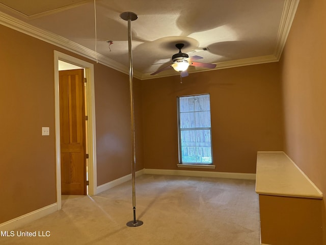 spare room with crown molding, ceiling fan, and light colored carpet