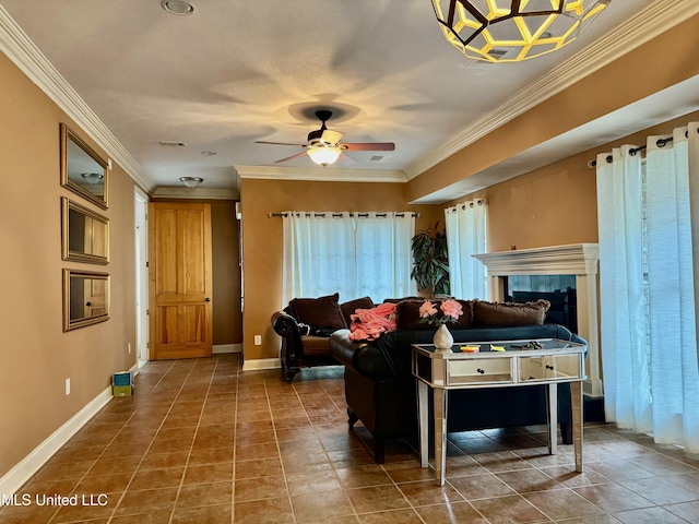 living room featuring ceiling fan, crown molding, and a tiled fireplace