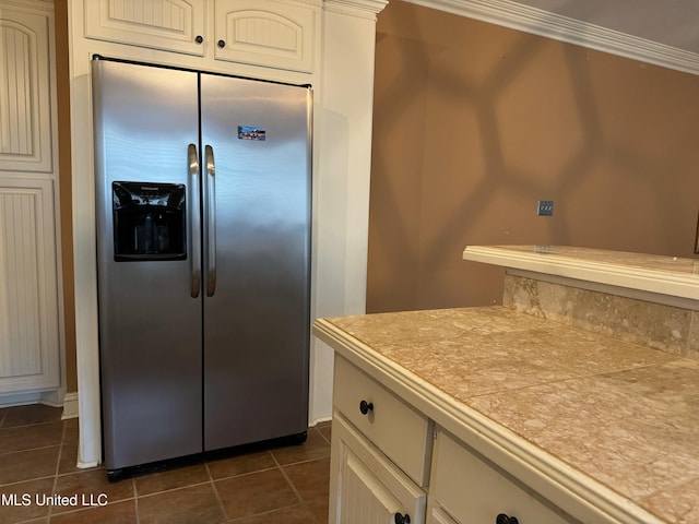 kitchen with tile countertops, crown molding, and built in fridge