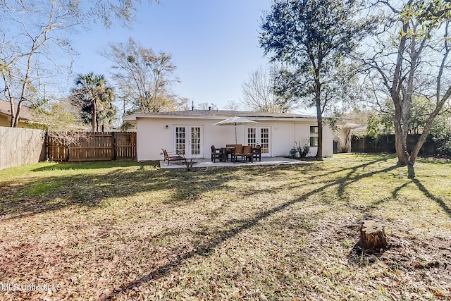 back of house featuring french doors, a patio, and a lawn