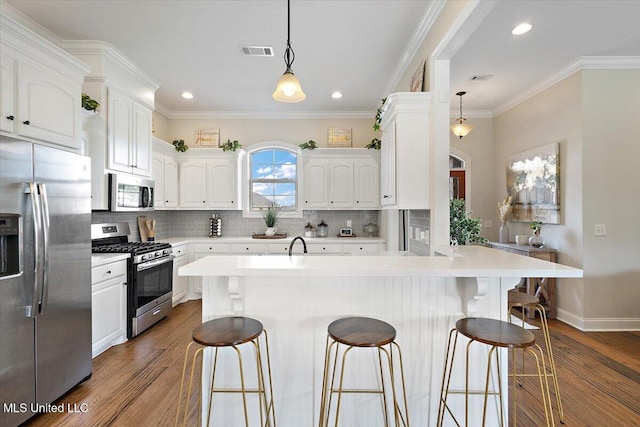 142 Western Ridge Cir, Canton, MS 39046 - kitchen with stainless steel appliances, a breakfast bar, dark wood-style flooring, backsplash, and recessed lighting
