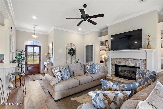 142 Western Ridge Cir, Canton, MS 39046 - living room featuring wood finished floors, a ceiling fan, recessed lighting, a fireplace with raised hearth, and built in features