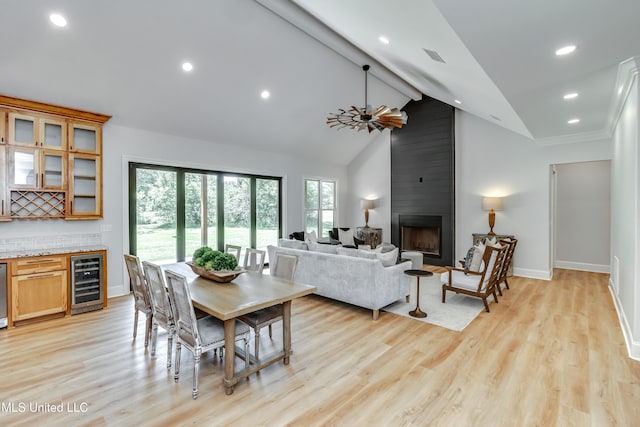 106 Horseshoe Ln, Flora, MS 39071 - dining room featuring beverage cooler, light wood-style floors, baseboards, a large fireplace, and beamed ceiling