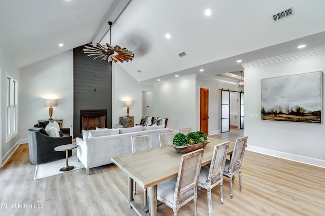 106 Horseshoe Ln, Flora, MS 39071 - dining area with crown molding, light wood-style flooring, baseboards, a barn door, and a fireplace