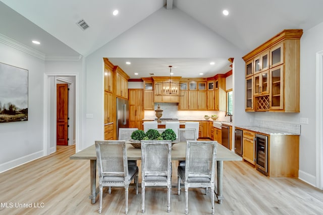 106 Horseshoe Ln, Flora, MS 39071 - kitchen featuring wine cooler, a center island, vaulted ceiling, light wood-type flooring, and a kitchen bar