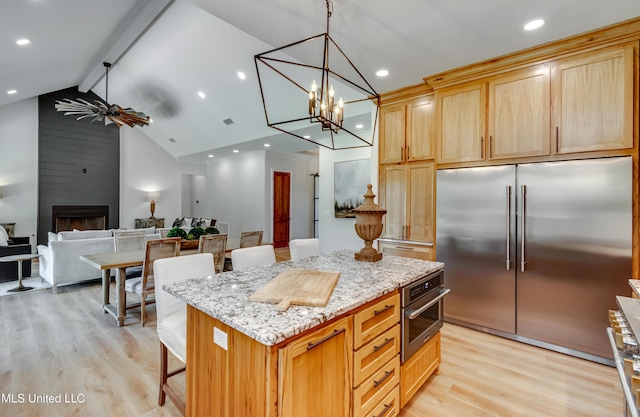106 Horseshoe Ln, Flora, MS 39071 - kitchen featuring premium appliances, light wood-type flooring, beamed ceiling, a breakfast bar area, and a kitchen island