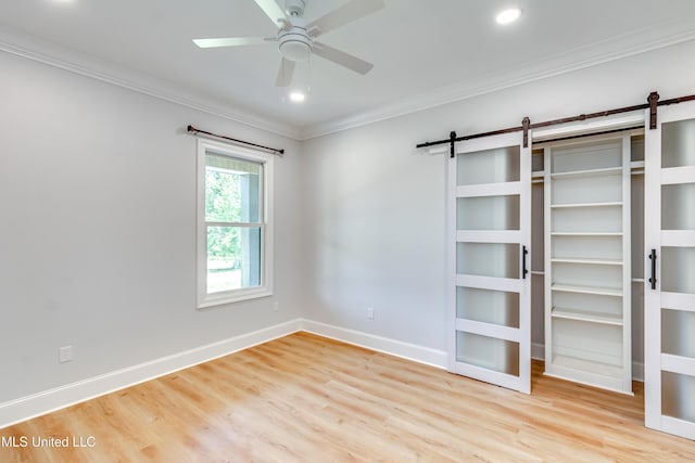 106 Horseshoe Ln, Flora, MS 39071 - unfurnished bedroom featuring a barn door, crown molding, wood finished floors, baseboards, and recessed lighting